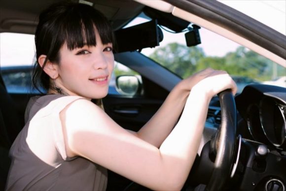 ドライブレコーダー付きの車を運転する女性